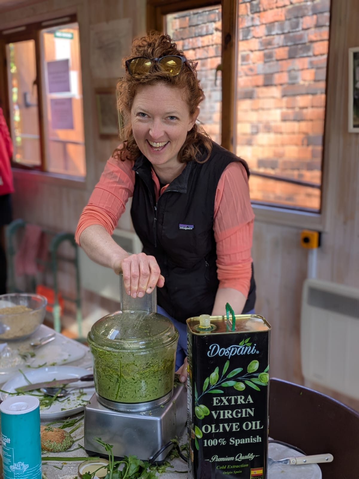 Hermione laughing while making pesto at a community kitchen