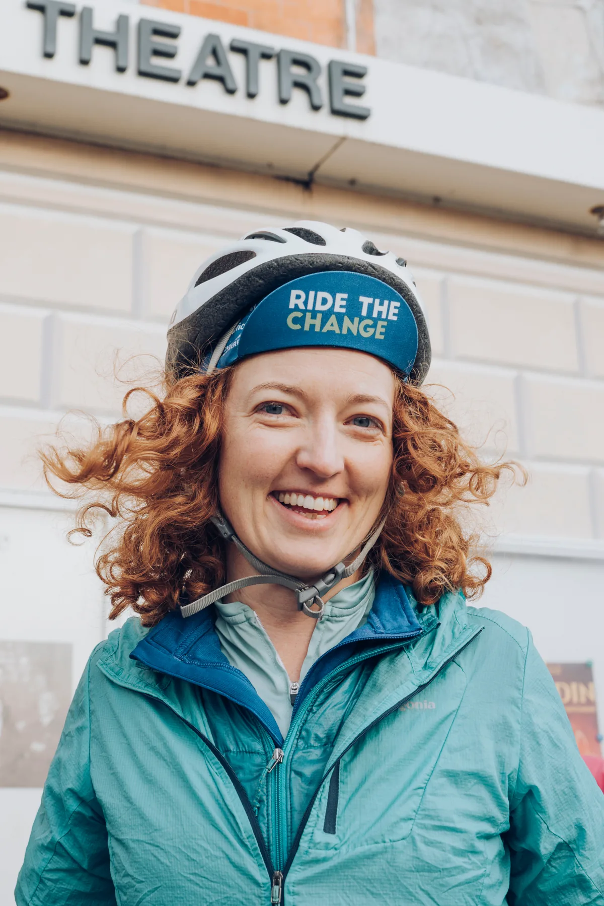 Hermione Taylor wearing a Ride the Change cycling helmet outside a theatre